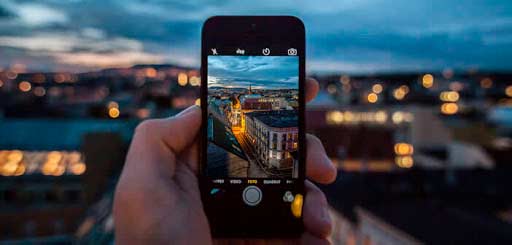 una persona sostiene un iPhone mientras hace una fotografía
